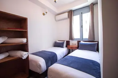 two beds in a room with a window at Cine House in Fès