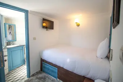 a small bedroom with a bed and a bathroom at Cine House in Fès