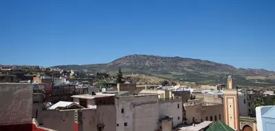 a view of a city with a mountain in the background at Cine House in Fès