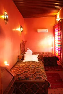a bedroom with two beds in a room at Riad Benchekroun in Meknès