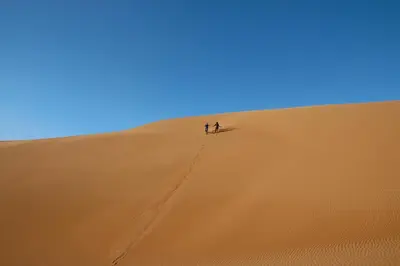 two people standing on top of a sand dune at Desert Atmosphere M'Hamid in Mhamid