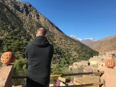 a man standing on a balcony looking down at a valley at Amlougui House in Marrakech