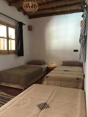 a room with three beds and a window at Amlougui House in Marrakech