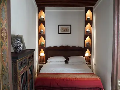 a bedroom with a bed and a wall with shelves at Dar Eva in Fès