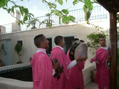 a group of men in pink robes standing in front of a building at Dar Eva in Fès