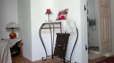 a room with a table with a lamp on it at Au Bord de l'Eau in Setti Fatma