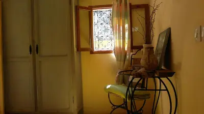 a room with a door and a window and a chair at Au Bord de l'Eau in Setti Fatma