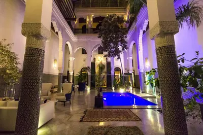 a lobby with a pool in the middle of a building at Riad Braya in Fès