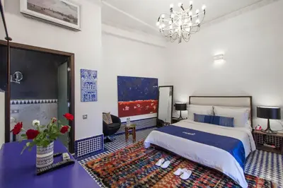 a bedroom with a king sized bed and a chandelier at Riad Braya in Fès