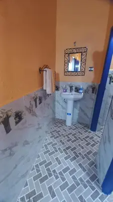 a bathroom with a sink and a mirror at Nomad Bivouac in Merzouga