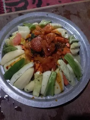 a bowl of food with vegetables and sauce in it at Nomad Bivouac in Merzouga