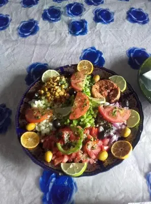 a plate of food with vegetables and fruit on a table at Nomad Bivouac in Merzouga