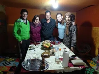 a group of people standing around a table at Nomad Bivouac in Merzouga