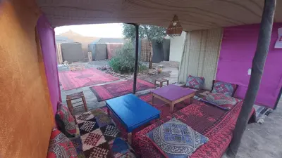 a room with a table and chairs in a tent at Nomad Bivouac in Merzouga