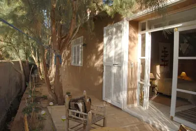 a porch with a bench and a tree next to a house at Villa Zagora Ma Villa au Sahara in Zagora