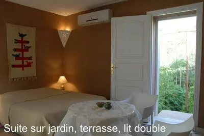 a bedroom with a bed and a table and a window at Villa Zagora Ma Villa au Sahara in Zagora