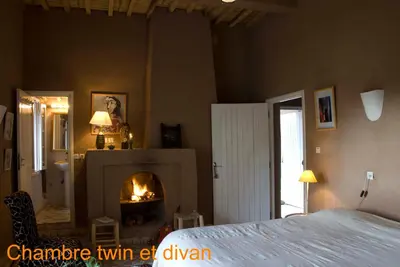 a bedroom with a fireplace and a bed in a room at Villa Zagora Ma Villa au Sahara in Zagora