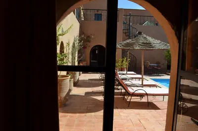 a view of a patio with an umbrella and a pool at Riad Dar Bergui in Ouarzazate