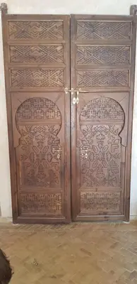a pair of wooden doors in a room at Riad Dar Bergui in Ouarzazate