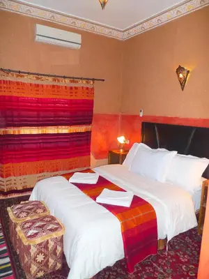 a hotel room with two beds with towels on them at Maison d'Hôtes Nouflla in Aït Ben Haddou