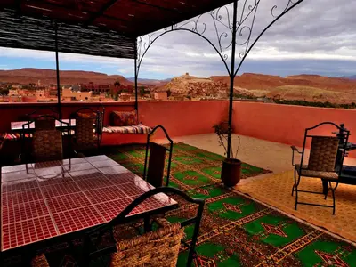 a patio with chairs and a view of the desert at Maison d'Hôtes Nouflla in Aït Ben Haddou