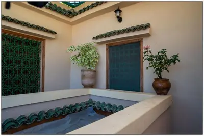 a house with two potted plants sitting on a porch at Riad Fés blida in Fès