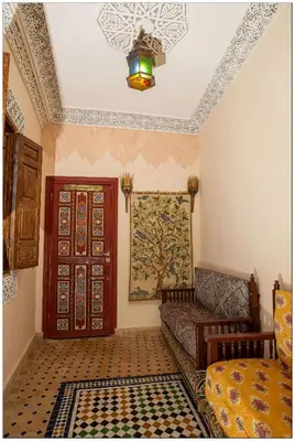a living room with a couch and a door at Riad Fés blida in Fès