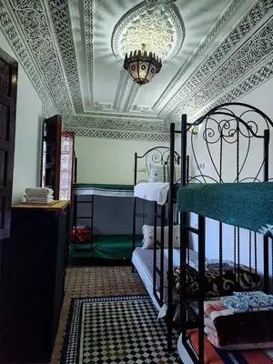 a bedroom with two bunk beds and a ceiling at Riad Fés blida in Fès