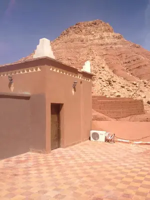 a small building with a mountain in the background at Kasbah Ounila in Aït Ben Haddou