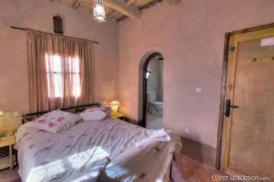 a bedroom with a large bed and a mirror at Kasbah Ounila in Aït Ben Haddou