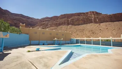 a swimming pool with a mountain in the background at Kasbah Hotel Camping Jurassique in Ifri