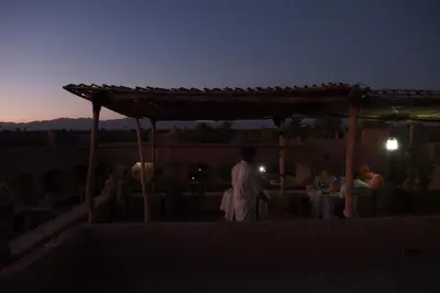 a man standing on top of a rooftop at night at Kasbah Dar Dmana in Skoura