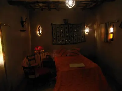 a bedroom with a bed and a table and chairs at Kasbah Dar Dmana in Skoura