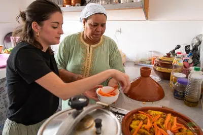 a woman standing in a kitchen preparing food at Ecolodge La Palmeraie in Ouarzazate