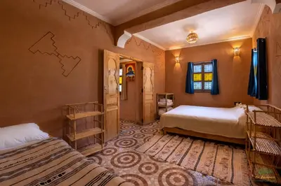 a bedroom with two beds and a map on the wall at Ecolodge La Palmeraie in Ouarzazate