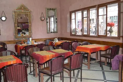 a restaurant with tables and chairs and a mirror at Hotel Atlas Ouarzazate in Ouarzazate