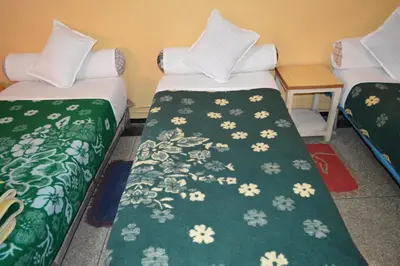 two beds in a room with green and white blankets at Hotel Atlas Ouarzazate in Ouarzazate