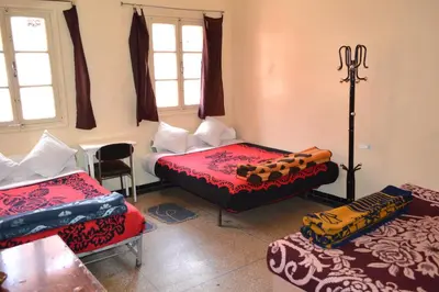 a room with three beds in a room at Hotel Atlas Ouarzazate in Ouarzazate