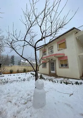 a snow man in front of a house with a tree at Villa ain soltan in Imouzzer Kandar