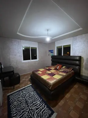 a bedroom with a bed and a chair and a piano at Villa ain soltan in Imouzzer Kandar