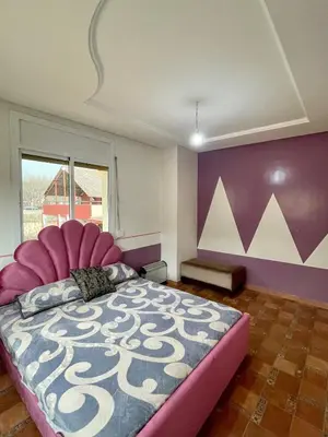 a bedroom with a large bed with a pink head board at Villa ain soltan in Imouzzer Kandar