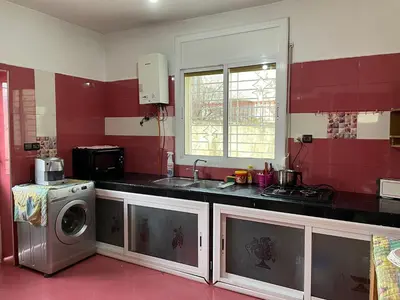 a kitchen with a sink and a washing machine at Villa ain soltan in Imouzzer Kandar