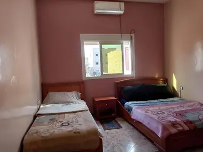 a bedroom with two beds and a window at Hôtel restaurant Palmiers in Alnif