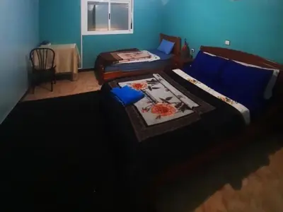 a bedroom with two beds with blue walls at Hôtel restaurant Palmiers in Alnif
