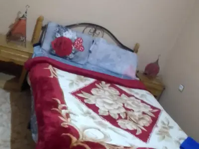 a bed with a blanket and pillows on it at Hôtel restaurant Palmiers in Alnif
