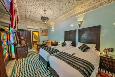 a hotel room with two beds and a couch at Riad Ghita Palace in Fès