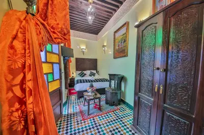 a room with a bedroom with a bed and a door at Riad Ghita Palace in Fès