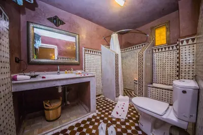 a bathroom with a toilet and a sink and a mirror at Riad Ghita Palace in Fès