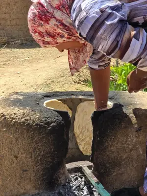 a young girl is standing on top of a well at Eco-Ferme Tamalait Skoura in Skoura