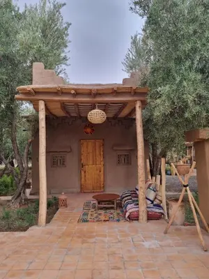 a pergola on a patio in front of a house at Eco-Ferme Tamalait Skoura in Skoura